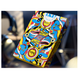 A colorful illustrated box of Beatles-themed poker chips, featuring cartoon blue figures, the Union Jack, and the word 'Beatles' on a yellow background, photographed against a blurred dark environment.