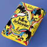The Beatles 'Yellow Submarine' premium playing cards box by Theory11, featuring a vibrant psychedelic illustration in yellow, blue, red, black, and white on a solid blue background.